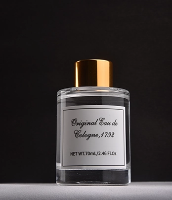 Original Eau de Cologne perfume bottle with gold cap on dark background.