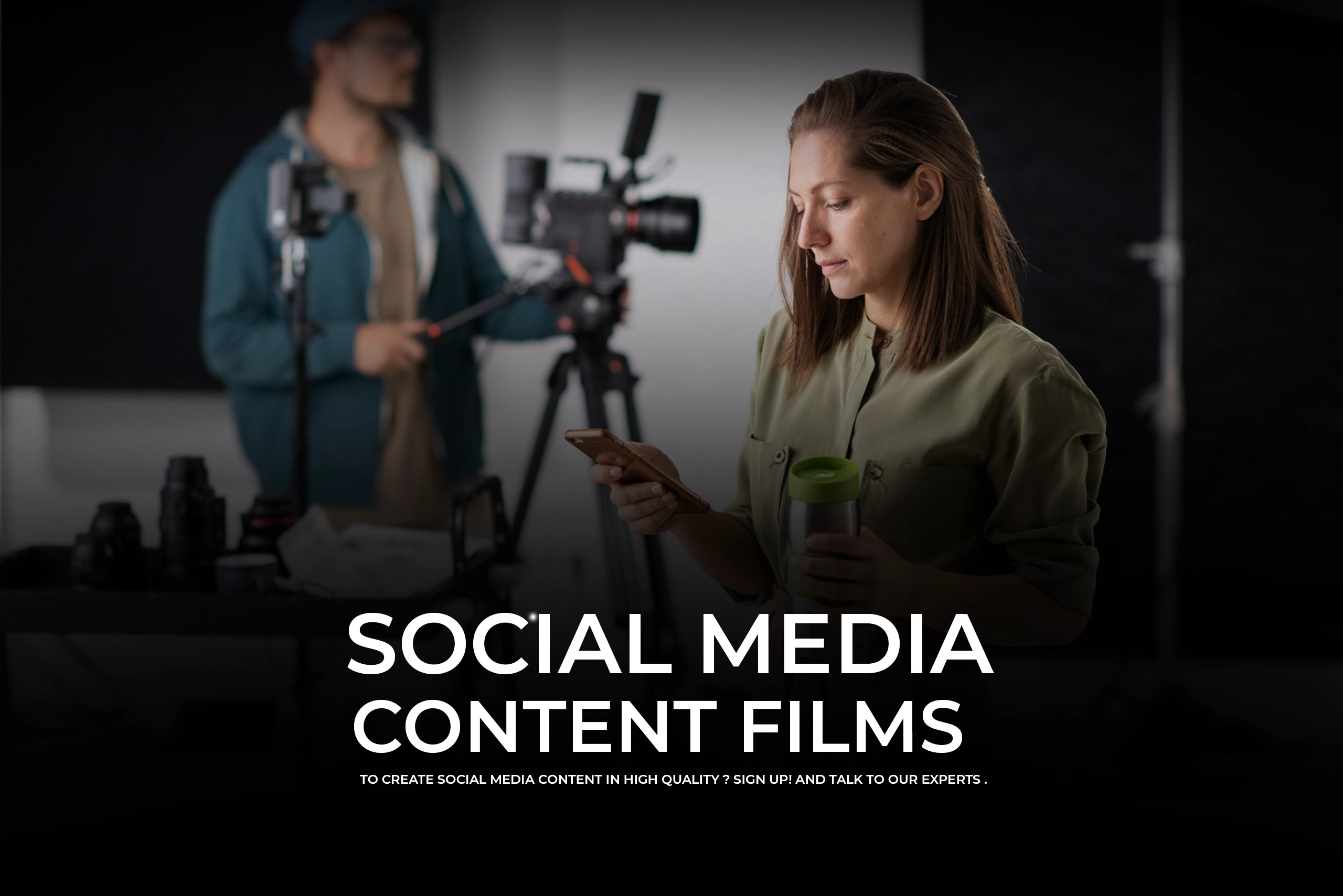 A professional media production scene featuring a woman in a green shirt checking her phone and holding a travel mug, with a cameraman and equipment blurred in the background. Bold text reads "SOCIAL MEDIA CONTENT FILMS."