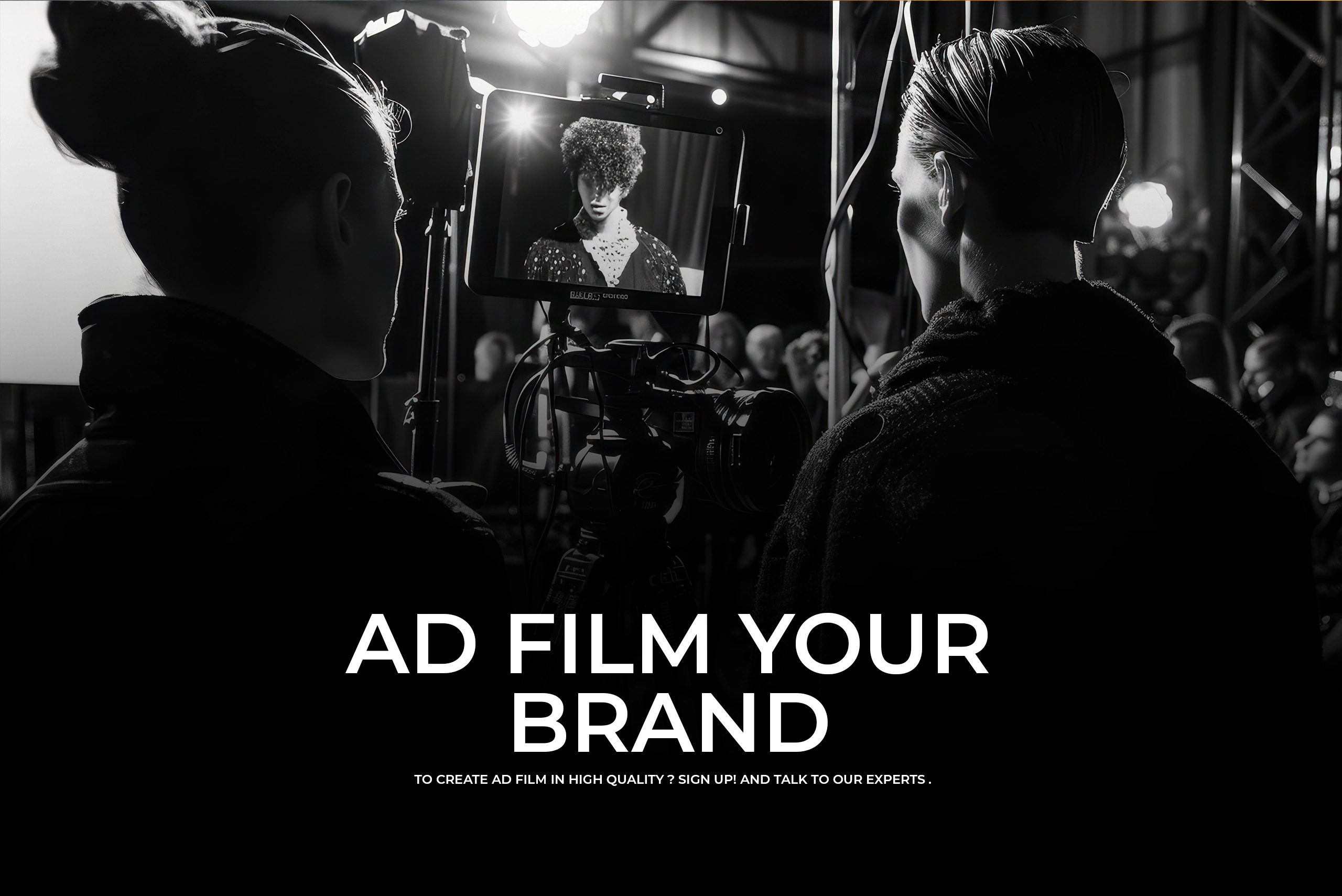 A black and white cinematic shot of a film crew monitoring a screen showing a model, with "AD FILM YOUR BRAND" in bold white text overlay.