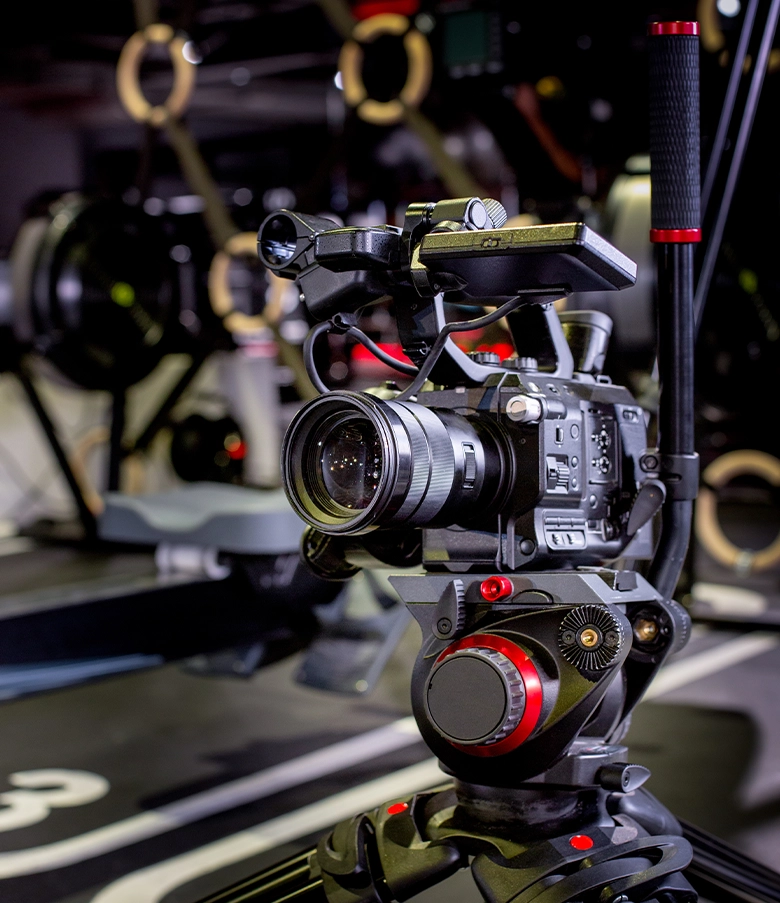 Professional video camera mounted on tripod in a studio setup.